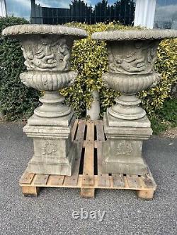Urns on bases Cast stone Pair Classic English stoneware urns with cherubs